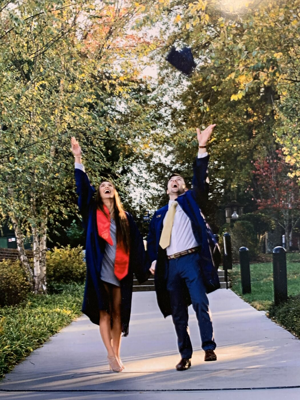 Dalton and Amber throwing graduation caps in the air